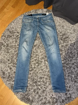 Dondup jeans - Snygga slim fit jeans i ljusblå denim med klassisk femficksdesign och diskreta slitningar. Jeansen har smal passform och normal midja, perfekta till en avslappnad streetstil. Materialet är bomullsdenim med lite stretch för extra komfort.