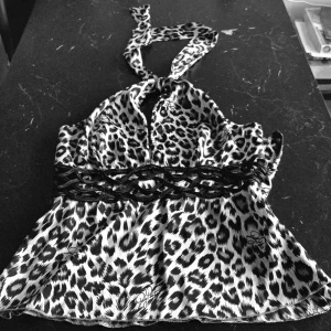 Baby Phat- ÄKTA Satin Snöleopard Mönstrad Halterneck Topp Stl M - Äkta Baby Phat Vara!  Designer Kimora Lee Simmons   Satin Snöleopard Mönstrad Halterneck Topp! Stl M ( 36-38 svensk stl)   Knytband vid nacken, tajt passform  Dragkedja vid ena sidan  Svart band vid bysten  Fint skick, använd 1 gång   