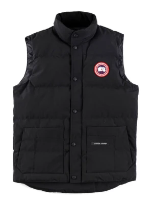 Svart dunväst från Canada Goose - Snygg svart dunväst från Canada Goose med hög krage och tryckknappar framtill. Västen har två stora fickor med lock och den klassiska Canada Goose-loggan på bröstet. Perfekt för lager-på-lager och riktigt varm tack vare dunfyllningen.