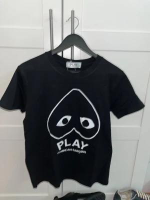 Svart T-shirt från comme des garçons - Svart t-shirt från Comme des Garçons PLAY med det ikoniska hjärtögon-trycket i vitt framtill, toppenskick. 🛑Skriv vid funderingar.                  🛑Snabb affär=kan gå ner i pris