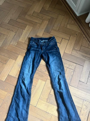 Mörkblå bootcut jeans från Cheap Monday - Snygga mörkblå bootcut jeans från Cheap Monday med klassisk femficksdesign och låg midja. Jeansen har en lätt tvättad look och är tillverkade i denim med stretch för extra komfort. Perfekta för en avslappnad och trendig stil. Aldrig använda