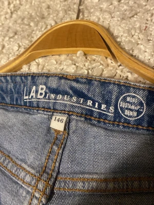 Blå raka jeans från LAB Industries - Säljer ett par ljusblå raka jeans från LAB Industries i hållbar denim. Jeansen har klassiska bakfickor och kontrastsömmar. Perfekta för en avslappnad och trendig look. Tillverkade i mer hållbart material.