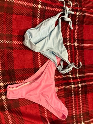 Pastellfärgad bikini med knyt - Säljer två bikini underdelar en ljusblå  och en rosa underdel. Den blåa har knyt i höfterna för justerbar passform. Båda delarna är i mjukt syntetmaterial och har en enkel, stilren design. Perfekt för sommardagar på stranden eller vid poolen.