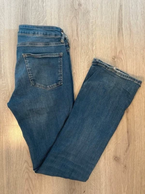Blå bootcut jeans från Zara - Snygga blå bootcut jeans från Zara. Storlek 38. I bra skick men de har slitningar i bensluten. 