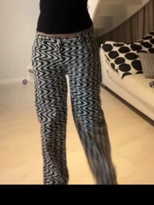 Svarta och vita zigzag-mönstrade jeans - Säljer ett par unika jeans med svart och vitt zigzag-mönster. Byxorna har rak passform och hög midja, perfekta för dig som vill sticka ut. Materialet känns mjukt och stretchigt för extra komfort. Grymma till sneakers eller boots!
