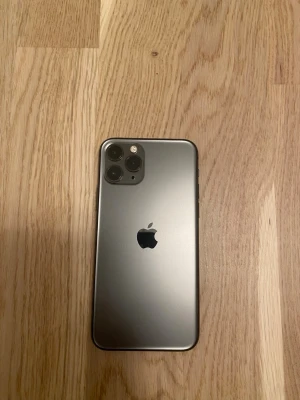 iPhone 11 Pro rymdgrå - Säljer en iPhone 11 Pro i snygg rymdgrå färg. Telefonen har en stilren design med glasbaksida och ram i rostfritt stål. Utrustad med trippelkamera på baksidan och stor skärm på framsidan. Perfekt för dig som gillar Apple och vill ha en kraftfull smartphone. 256 gb och 100% batterihälsa. Kom gärna in med byten!