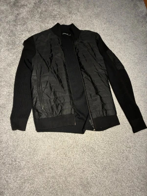 J.Lindeberg cardigan - J.Lindeberg cardigan i storlek L. Mycket bra skick, ena fickan går ej att öppna och ena går ej att stänga. Men annars mycket bra