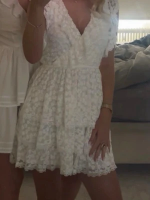 Studentklänning  - Säljer denna söta vita klänning som är parfekt till studenten. Från Nelly i storlek XS och är i fint skick, inga skavanker. Hör av er vid funderingar! 🤍