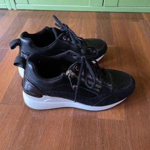 Svarta sneakers med kilklack - Lätt använda, utan skador bara lätt slitage under sulorna.