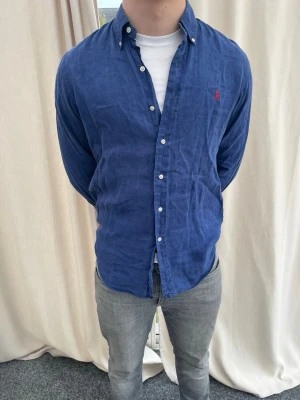 Blå linneskjorta från Ralph Lauren - Snygg blå skjorta i linne från Ralph Lauren. Strl M, personen på bilden är 184 cm lång. Skicka gärna prisförslag. Kika in min profil för mer schyssta plagg. 