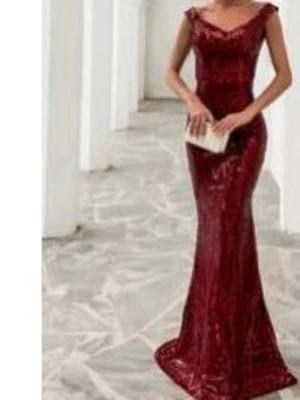 Vinröd långklänning med paljetter - Elegant vinröd långklänning med glittriga paljetter och v-ringad urringning. Klänningen har en figurnära passform och är ärmlös, perfekt för speciella tillfällen. Materialet ger en lyxig känsla och klänningen har en klassisk, tidlös siluett.