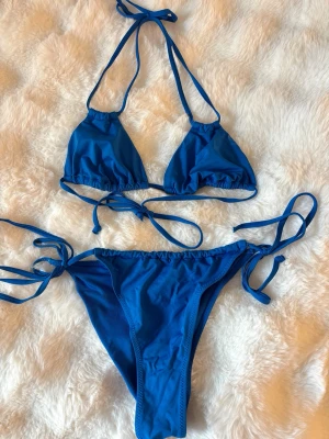 Blå trekantsbikini med knyt - Snygg blå trekantsbikini med knyt både i nacken, ryggen och på sidorna av bikinitrosan. Klassisk modell som ger en enkel och stilren look🤩🤩