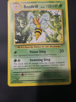 Beedrill Pokémonkort 2016 - Säljer ett Beedrill Pokémonkort från 2016 med gul ram och klassisk design. Kortet har illustration av Beedrill och detaljer om attacker och HP. Perfekt för samlare eller Pokémonfans som vill utöka sin kortsamling.