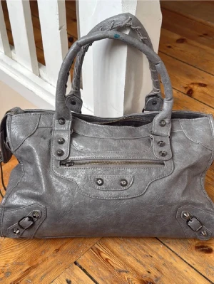 Grå skinnväska med nitar - Snygg grå handväskan acceptabelt skick, swepa på de olika bilderna för att se, därav pris, hör av dig för fler bilder eller frågor!!!💕💕