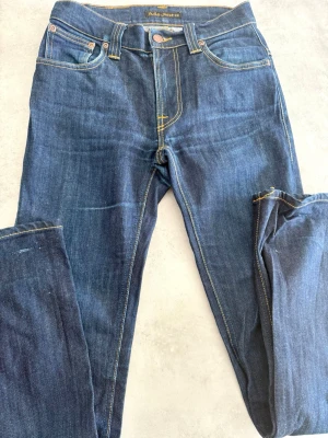 Snygga nudie jeans - Fina nudie jeans med vitt mönster på backfickorna och dessa är i riktigt bra skick med inga defekter. Dom är i storlek 28/32 och är rätt så tighta, hör bara av er vid funderingar.