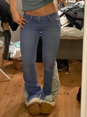 Lågmidjade jeans med spets - Säljer dessa så fina och unika jeans som är omsydda till bootcut med spets. Midjemått 37 cm och innerbenslängd 75 cm. Dragkedjan till jeansen är lite hackig men så länge men drar försiktigt så funkar den. Obs hunden är ej till salu🤗🤗💕