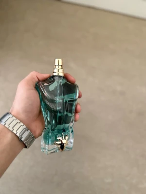 Jean Paul Gaultier Le Male parfym 125ml - Cool parfymflaska från Jean Paul Gaultier formad som en manlig torso i blått glas med guldfärgad spraytopp. Flaskan har en unik design och är riktigt snygg att ha framme på hyllan. Kommer tyvärr inte med boxen då jag har slarvat bort den.  90% kvar 