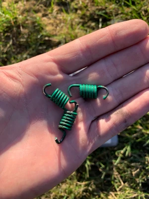 Kopplingsfjäder och tryckfjäder - Gröna kopplingsfjädrar och en vit tryckfjäder