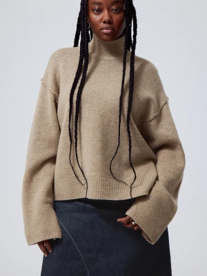 Beige oversized polotröja - Säljer en beige oversized stickad polotröja med breda ärmar och ribbade muddar. Tröjan har hög krage och avslappnad passform, perfekt för lager på lager. Materialet ser ut att vara mjukt och mysigt, troligen ull eller ullmix. Lite nopprig men ser fortfarande väldigt bra ut när man använder 