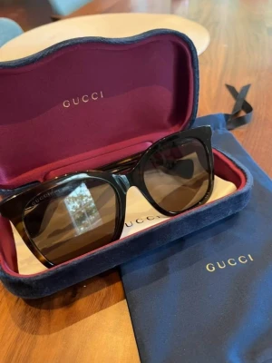 Svarta solglasögon från Gucci - Snygga svarta solglasögon från Gucci med klassisk cat-eye form och mörka glas. Inköpta ett år sen och knappt använda. Kvitto finns. Köpta för 3400.