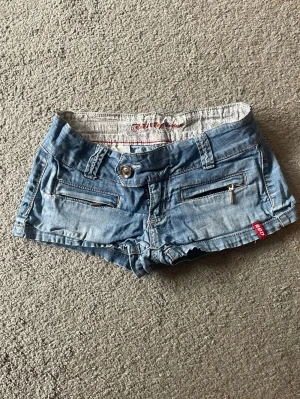 Mini jeansshorts - Bra skick, lite urtvättade. Midjemått rakt över 38+mycket stretch grenhöjd 16,5 längd (sida) 20cm!