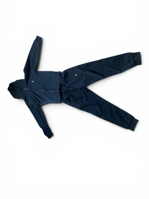 Ralph lauren tracksuit - Svart tracksuit från Ralph Lauren med dragkedja framtill och klassisk huva. Tröjan har små vit färgade broderade loggor på bröstet och byxan, samt ribbade muddar vid ärmslut och benslut. Perfekt för en avslappnad och sportig stil. Har inte använt mycket eftersom ja har växt sen ja fick den