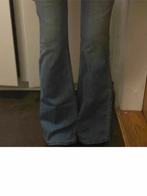 Low waist bootcut jeans  - Säljer ett par klassiska blå bootcut jeans från Hollister med låg midja. Jeansen har snygga detaljerade bakfickor och är tillverkade i mjukt denimtyg. Innerbenlängd:82 cm och Midja 35cm. Men dom är ❤️stretchiga Inga defekter!