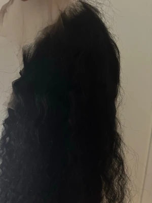 Svart lockigt löshår clip-in - Säljer en  svart lockig Wig Håret är långt och har naturliga lockar som ger volym och en snygg look. Perfekt för dig som vill ha extra längd och fyllighet i håret.