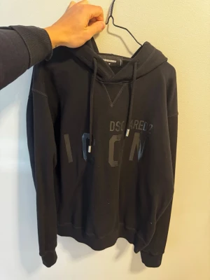 Svart hoodie från Dsquared2 ICON - Svart hoodie från Dsquared2 med stor huva och dragsko. Köpt från Johnells..  använd få tal gånger..