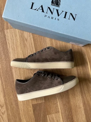 Lanvin cap toe  - Säljer ett par bruna/gråa Lanvin cap toe i mycket fint skick. Skorna är i storlek uk 7 = 41 eu men sitter mer som 42 eu då Lanvin är stora i storleken. Orginallåda medföljer vid köp. Kom om för fler bilder eller frågor 🫡