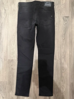Replay Anbass Jeans Svarta W32/L34 - Slim Fit - Replay Anbass svarta jeans med slim fit passform som sitter snyggt och bekvämt och funkar till allt, storlek W32/L34, midja 41 cm, ytterbenslängd 106,5 cm, benöppning 15,5 cm, modellen är 185cm & väger 65kg, i fint skick.