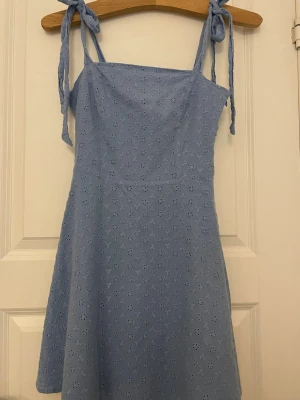 Broderad klänning - Fin broderad klänning från NA-KD. Använd, men i fint skick. Har axelband med knytning som man lätt kan justera storleken på. Skulle säga att den är lite mindre i storleken. Skriv gärna vid frågor