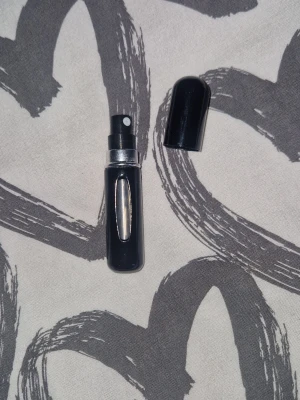 Parfymatomizer - Helt ny, tom snygg och smidig svart parfymatomizer i metall med silverdetalj. Perfekt att fylla med din favoritdoft och ha med i väskan. Fönster på sidan så du ser hur mycket parfym som är kvar. Liten och lätt att ta med överallt. 