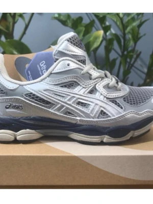 Grå Asics sneakers med mesh - Snygga sneakers från Asics i grått och vitt med meshpaneler och detaljer i silver. Skorna har en sportig design med Ortholite innersula och mörkblå sula. Perfekta för dig som gillar en clean och modern look.