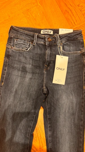 Mörkblå skinny jeans från ONLY storlek S /32 - Snygga mörkblå skinny jeans från ONLY med klassisk femficksmodell och normalhög midja. Jeansen har en smal passform hela vägen ner och är tillverkade i stretchigt denimtyg för extra komfort. Perfekta till en avslappnad och trendig look.