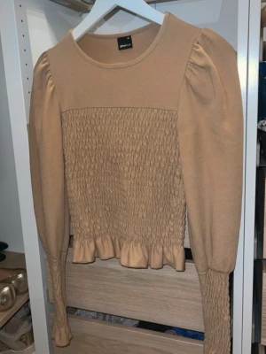 Beige topp med puffärm och volang - Använd ett få tal gånger