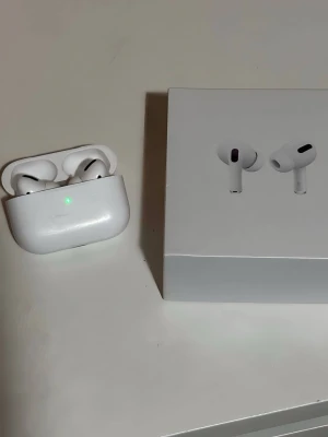 Apple AirPods Pro trådlösa hörlurar - Säljer ett par vita Apple AirPods Pro med laddningsetui och originalförpackning. Hörlurarna har in-ear design, silikonproppar och stilren form. Perfekta för dig som vill ha grymt ljud och smidig anslutning till din iPhone eller andra Apple-enheter.