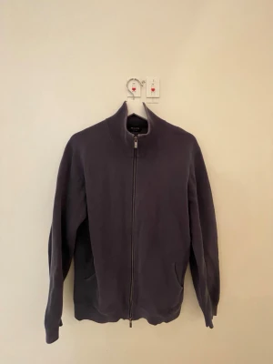 Blå ziptröja från Massimo Dutti - Snygg ziptröja från Massimo Dutti i bomull. Tröjan har hög kragen och dragkedja framtill. Perfekt för dig som gillar stilrena och bekväma plagg med en modern touch. Använts en del, därav bra pris. 