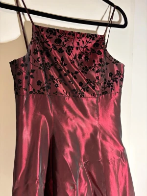 Vintage balklänning  - Så vacker balklänning! Tillverkad i USA, 90s stil vinröd med broderade blommor längst fram. Vintage, köpt för 1000. Pris kan diskuteras 🩷🩷passar mig som är 170 cm, s/m. Hör av dig vid frågor/bilder!