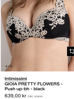 Svart push up-bh med spets från Intimissimi  - Snygg svart push up-bh från Intimissimi med vacker beige spetsbrodyr i blommönster. Bh:n har vadderade kupor och bygel för extra stöd och lyft. Axelbanden är justerbara och modellen ger en feminin och elegant look. Använd väldigt sparsamt 