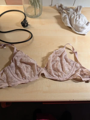 Ljusrosa spets-bh med justerbara band - Söt ljusrosa bh i spets med tunna, justerbara axelband och mjuka kupor utan vaddering. Romantisk design med fina spetsdetaljer och lätt volangkant nedtill. Perfekt för dig som gillar en feminin och bekväm stil.