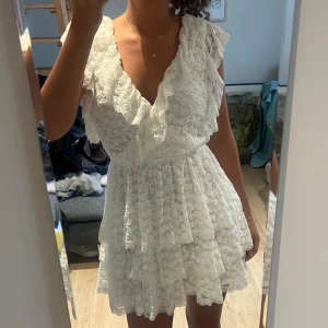 Studentklänning från nelly - Säljer min jättefina korta studentklänning!! Endast använd en gång så nyskick💛Klänningen har fina volanger och knytning där bak och en öppen rygg. Klänningen är från Nelly, förra årets kollektion🙌Perfekt för studenten eller som sommarklänning💛skriv vid funderingar