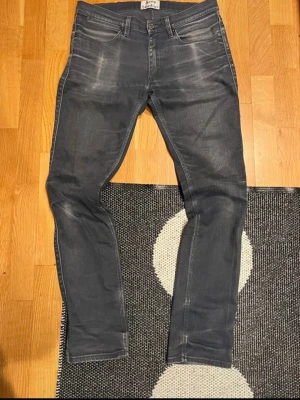 Gråa slim jeans från acne studios - Snygga grå slim jeans från Acne Studios med slitna detaljer och klassisk femficksmodell. Jeansen har en slim passform och är tillverkade i stretchigt denimtyg för extra komfort. W31 l32 ytterbenslängd 100cm midja 82cm. Kom gärna med frågor.