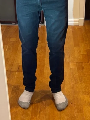 Svarta replay jeans - Svarta jeans från Replay, modell Anbass, i storlek W32 L32. Jeansen är i extremt bra skick utan några defekter. Personen på bilden är cirka 180 cm som referens för passformen. Nypris ligger på 1500 kr. Måtten är: midjemått 44 cm och längd 110 cm.  Kolla gärna in profilen också, där finns flera märkeskläder och skor – du hittar säkert något mer som passar 😉💯 Hör av dig om du undrar något!