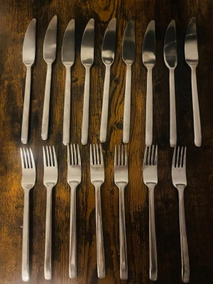 Set med knivar och gafflar i rostfritt stål - Säljer ett set med nio knivar och sju gafflar i rostfritt stål. Besticken har en enkel, modern design med raka linjer och matt finish. Perfekt till köket eller som extra bestick till middagsbjudningar.