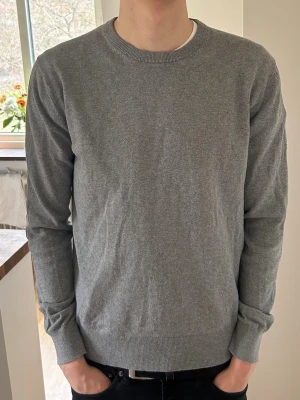 Stickad Tröja från Ellos - Säljer en mörkgrå stickad tröja från Ellos Collection i nytt skick. Inte använd så mycket (ca 5 gånger) eftersom den blev för liten efter första tvätten. Nypris 349 kr på Ellos. Jag är 188 cm och väger 72 kg för den som vill jämföra :)