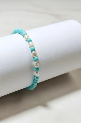 Handgjort armband med sötvattenpärlor - Handgjort armband med äkta sötvattenpärlor  Ett elegant och minimalistiskt smycke som passar perfekt till sommaren!💕  Armbandet är elastiskt och är ca 17 cm. Varje armband är unikt  ✨ Detaljer  - Handgjort - Färg: Turkos/vit - Material: Seed beads & sötvattenpärlor - Storlek: 17 cm - Typ: Elastiskt  💌 Kolla gärna mina andra smycken
