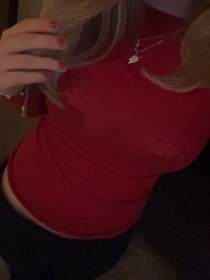 Röd mesh topp med lång ärm - Snygg röd mesh topp med lång ärm och tight passform. Transparent material som ger en trendig look, perfekt att styla med smycken och höga byxor. Hög hals och figurnära modell för en modern vibe.