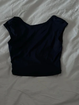 croppad topp med breda axlar - Snygg croppad topp med breda axlar och rund halsringning. Toppen är ärmlös och har en stilren, minimalistisk design som passar perfekt till både jeans och kjol. Tillverkad i mjukt material för en bekväm känsla.