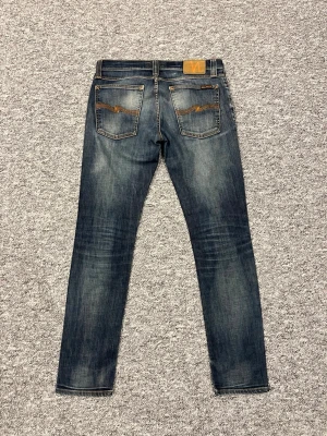 Mörkblå jeans från Nudie - Snygga mörkblå slim fit jeans från Nudie med snygga tvättfläckar vilket gör dem extremt snygga. Det är storlek W30 och L32. Hör gärna av dig vi frågor👑